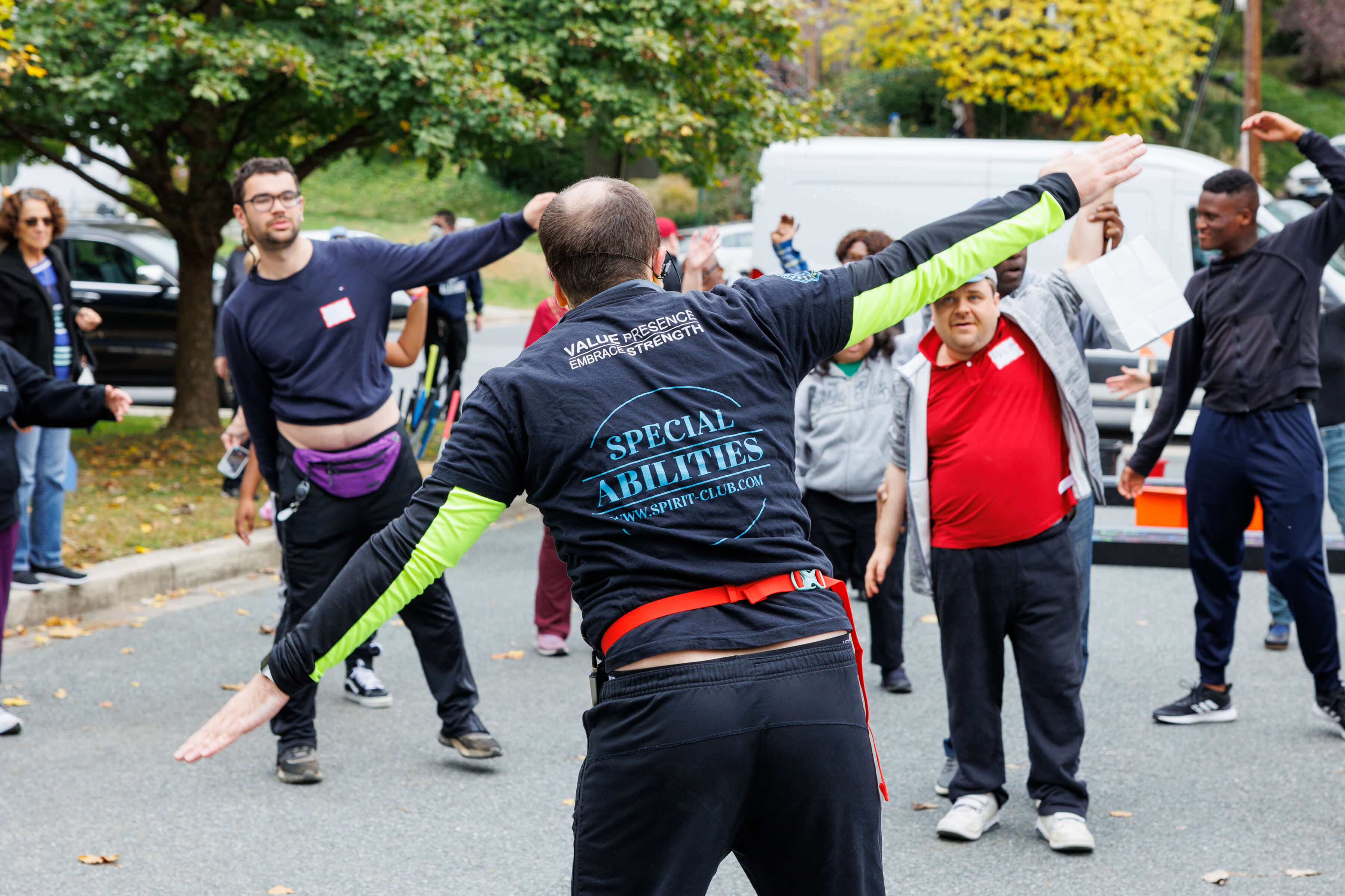 athletes with disabilities being led in group stretches by a trainer