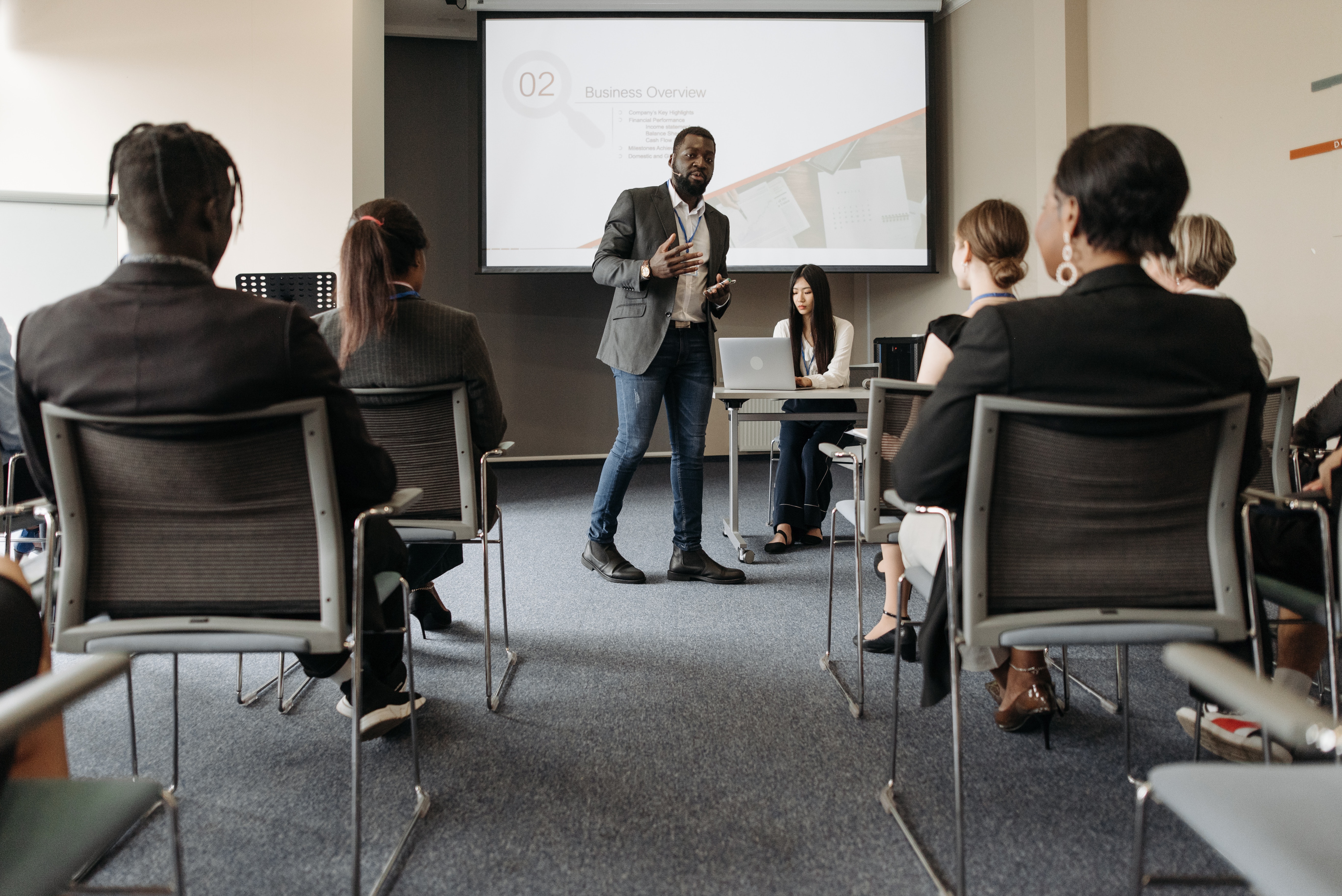 Man giving a presentation of slide decks to a room of people 