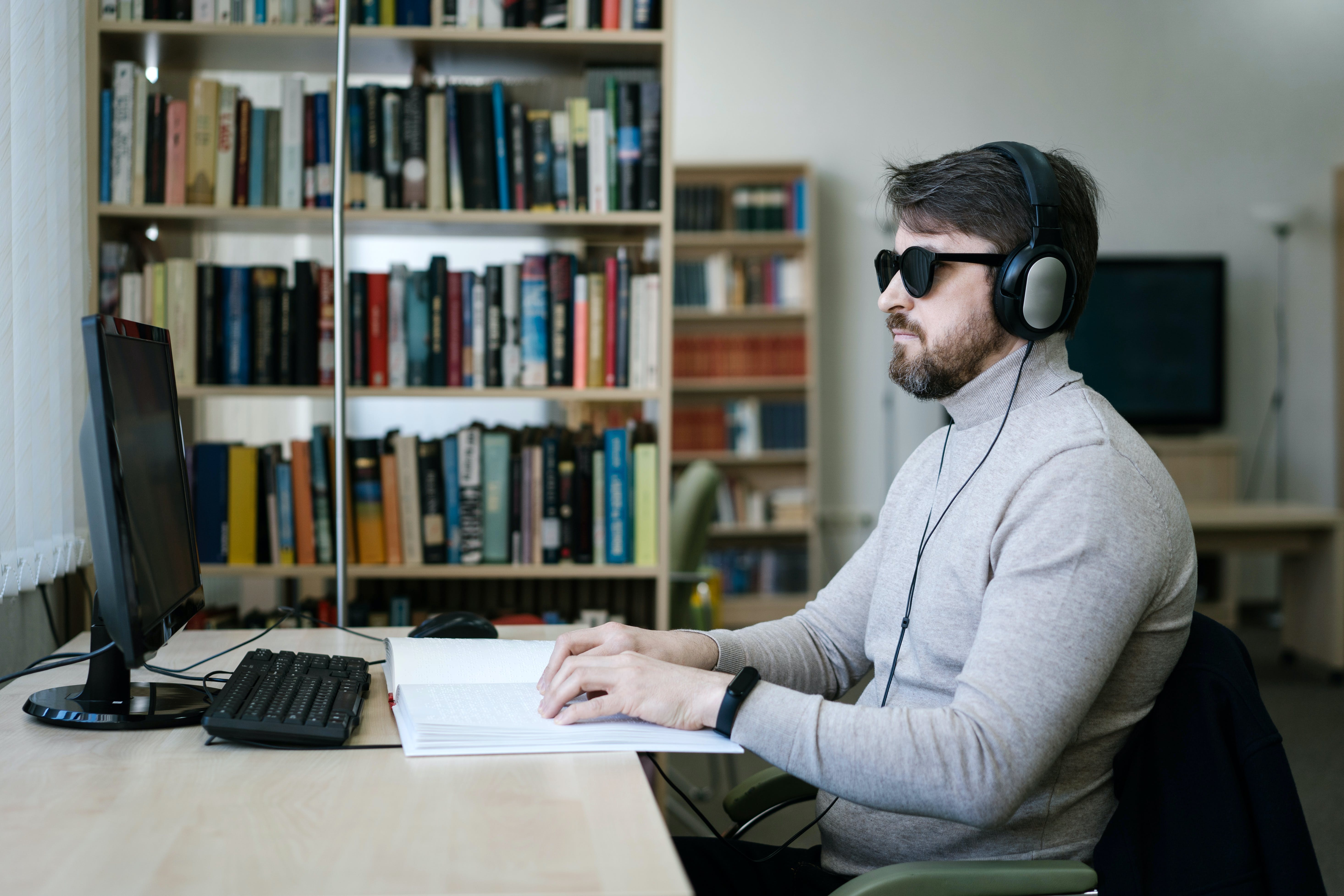 blind person using a laptop and wearing headphones